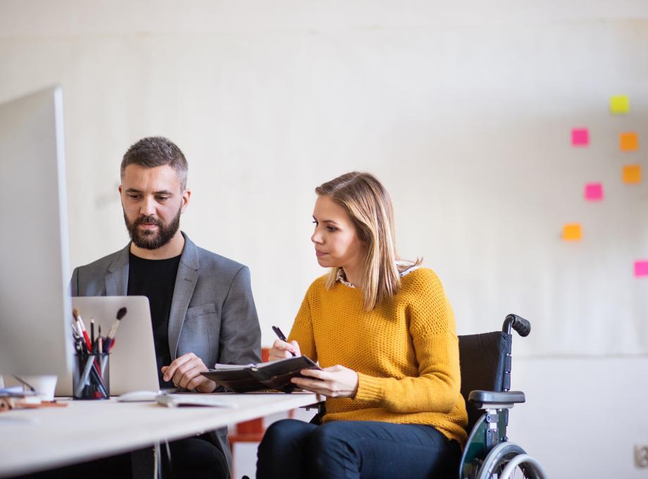 Jeune femme en fauteuil roulant travaillant à son bureau
