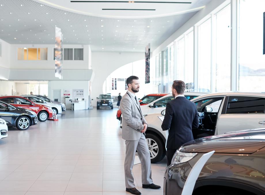 Deux hommes discutant dans le showroom d'un concessionnaire automobile