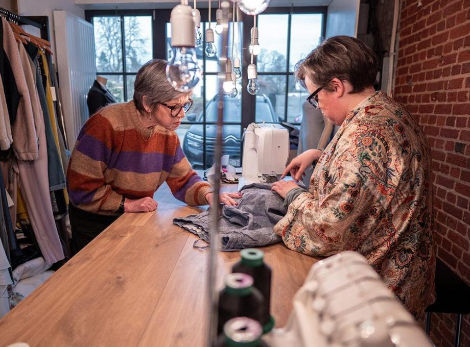 Deux femmes se concentrent sur la couture dans un atelier lumineux et moderne.